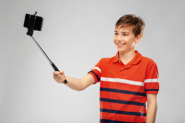 Image showing boy taking picture with smartphone on selfie stick