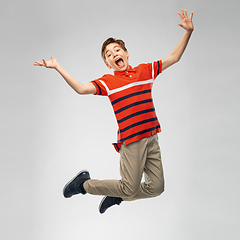 Image showing happy smiling young boy jumping in air