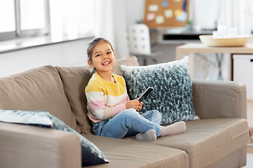 Image showing happy smiling little girl with smartphone at home