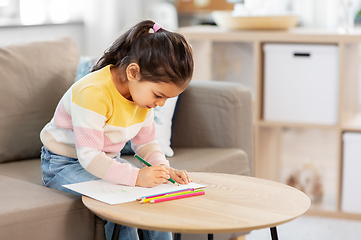 Image showing little girl drawing with coloring pencils at home
