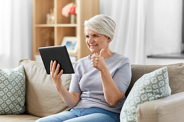 Image showing senior woman having video chat on tablet pc