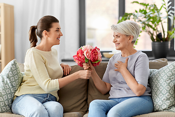 Image showing adult daughter giving flowers to old mother