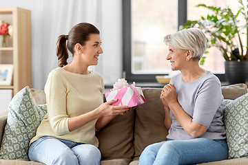 Image showing adult daughter giving present to her senior mother