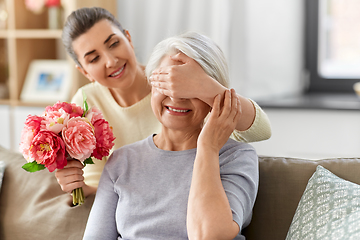 Image showing adult daughter giving flowers to old mother