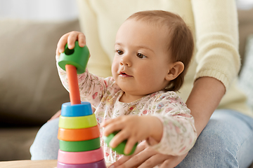 Image showing lovely baby girl playing with toy pyramid at home