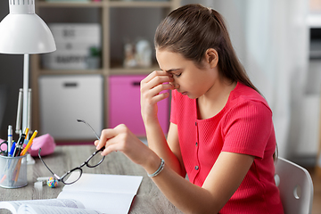 Image showing tired teenage student girl with glasses at home