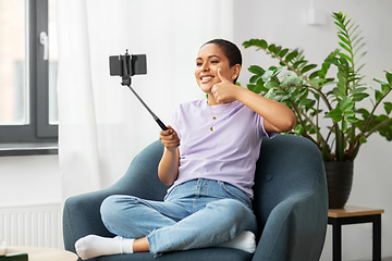 Image showing happy african american woman taking selfie at home