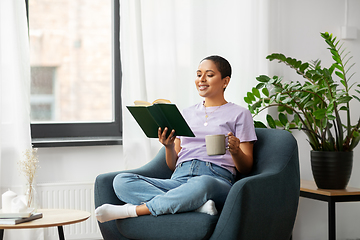 Image showing happy african american woman reading book at home