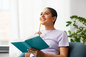 Image showing happy african american woman with diary at home