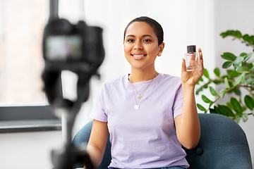 Image showing female beauty blogger with camera and perfume