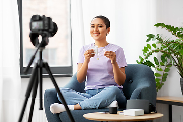 Image showing female blogger with camera video blogging at home