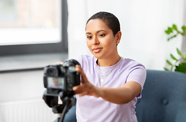 Image showing female video blogger adjusting camera at home