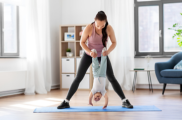 Image showing happy mother with little baby exercising at home