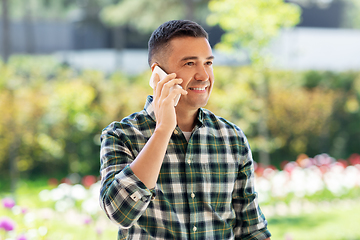 Image showing happy man calling on smartphone at summer garden