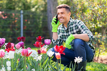 Image showing man with flowers calling on smartphone at garden