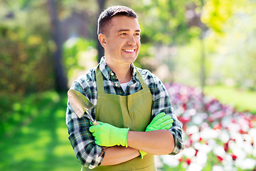 Image showing happy man in apron with scoop at summer garden