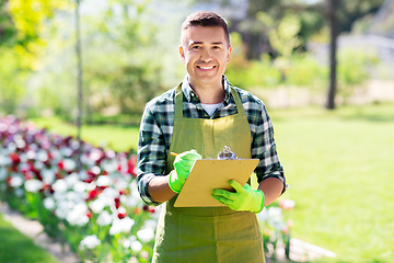 Image showing happy man with clipboard at summer garden