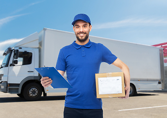 Image showing happy delivery man with parcel box and clipboard