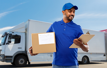 Image showing indian delivery man with parcel box and clipboard