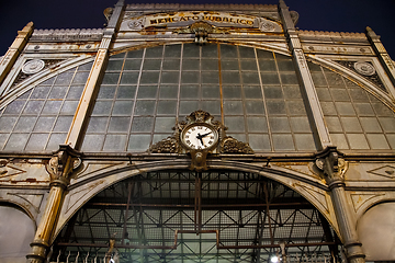 Image showing Old clock hanging on ancient market wall.