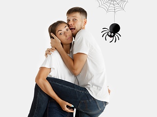 Image showing Colorful drawing in cartoon style collaged with portrait of young caucasian couple. Woman holding her man that scared of spider