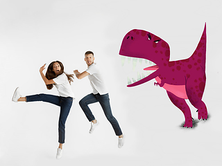 Image showing Colorful drawing in cartoon style collaged with portrait of young caucasian couple running from dinosaur