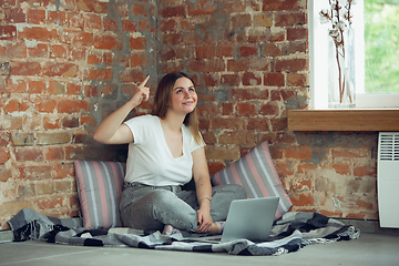 Image showing Young woman, businesswoman working or studying at home with laptop near window. Attented, concentrated. Copyspace.