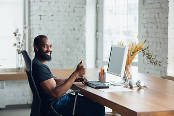 Image showing Young man, businessman working in office, looking on blank black computer screen, monitor. Copyspace.