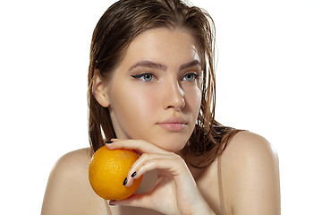 Image showing Skincare. Beautiful young woman with orange over white background. Cosmetics and makeup, natural and eco treatment.