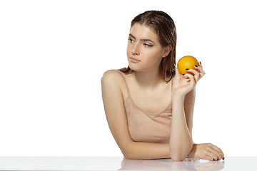 Image showing Skincare. Beautiful young woman with orange over white background. Cosmetics and makeup, natural and eco treatment.