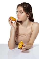 Image showing Organic. Beautiful young woman with orange slices over white background. Cosmetics and makeup, natural and eco treatment, skin care.