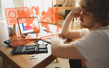 Image showing Interface modern technology and digital layer effect. Man counting, working in despair, went bankrupt. Business, finance crisis, economics recession, unemployment concept.