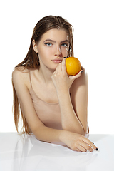 Image showing Healthcare. Beautiful young woman with orange over white background. Cosmetics and makeup, natural and eco treatment, skin care.