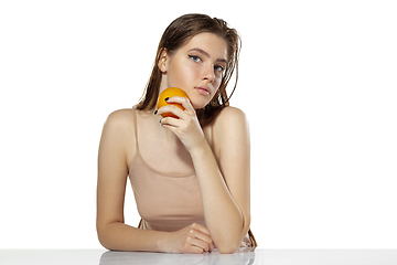 Image showing Skincare. Beautiful young woman with orange over white background. Cosmetics and makeup, natural and eco treatment.