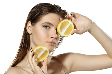 Image showing Organic. Beautiful young woman with lemon slice over white background. Cosmetics and makeup, natural and eco treatment, skin care.