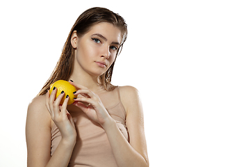 Image showing Youth secrets. Beautiful young woman with lemon over white background. Cosmetics and makeup, natural and eco treatment, skin care.