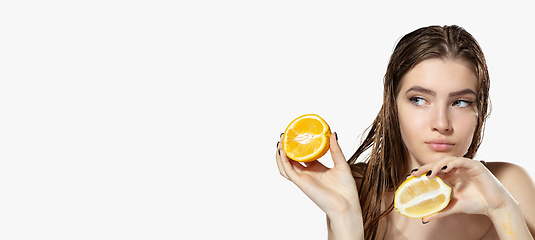 Image showing Youth secrets. Close up of beautiful young woman with lemon and orange slices over white background. Cosmetics and makeup, natural and eco treatment, skin care. Flyer with copyspace.