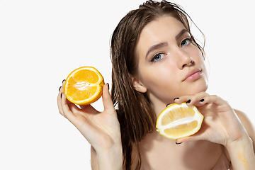 Image showing Youth secrets. Close up of beautiful young woman with lemon and orange slices over white background. Cosmetics and makeup, natural and eco treatment, skin care.