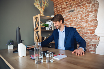 Image showing Young man, manager, team led return to work in his office after quarantine, feels happy and inspired