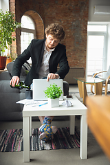 Image showing Young man without pants but in jacket working on a computer, laptop. Remote office during coronavirus, fun and comfortable work in underpants