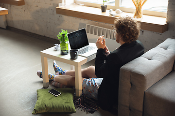 Image showing Young man without pants but in jacket working on a computer, laptop. Remote office during coronavirus, fun and comfortable work in underpants