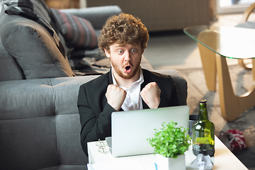 Image showing Young man without pants but in jacket working on a computer, laptop. Remote office during coronavirus, fun and comfortable work in underpants