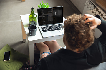 Image showing Young man without pants but in jacket working on a computer, laptop. Remote office during coronavirus, fun and comfortable work in underpants