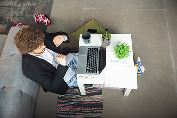 Image showing Young man without pants but in jacket working on a computer, laptop. Remote office during coronavirus, fun and comfortable work in underpants