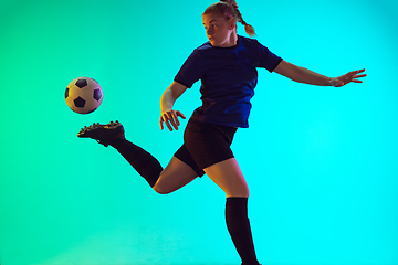 Image showing Female soccer, football player kicking ball, training in action and motion with bright emotions isolated on gradient background