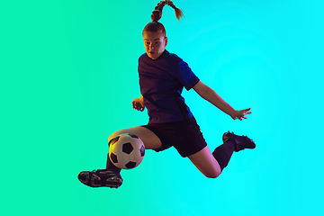 Image showing Female soccer, football player kicking ball, training in action and motion with bright emotions isolated on gradient background