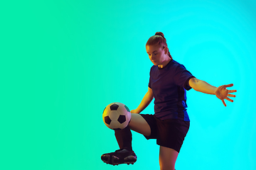 Image showing Female soccer, football player kicking ball, training in action and motion with bright emotions isolated on gradient background