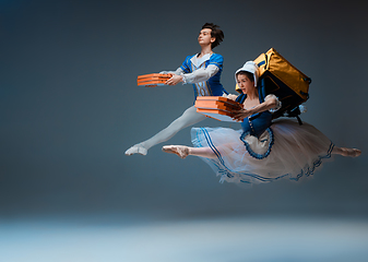 Image showing Young and graceful ballet dancers as Cinderella fairytail characters hurrying up with pizza like deliveryman