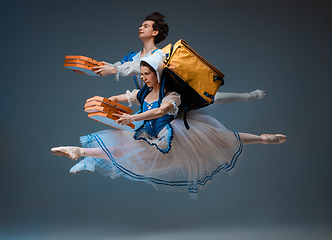 Image showing Young and graceful ballet dancers as Cinderella fairytail characters hurrying up with pizza like deliveryman