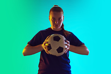 Image showing Female soccer, football player holding ball, posing confident isolated on gradient background. Copyspace.